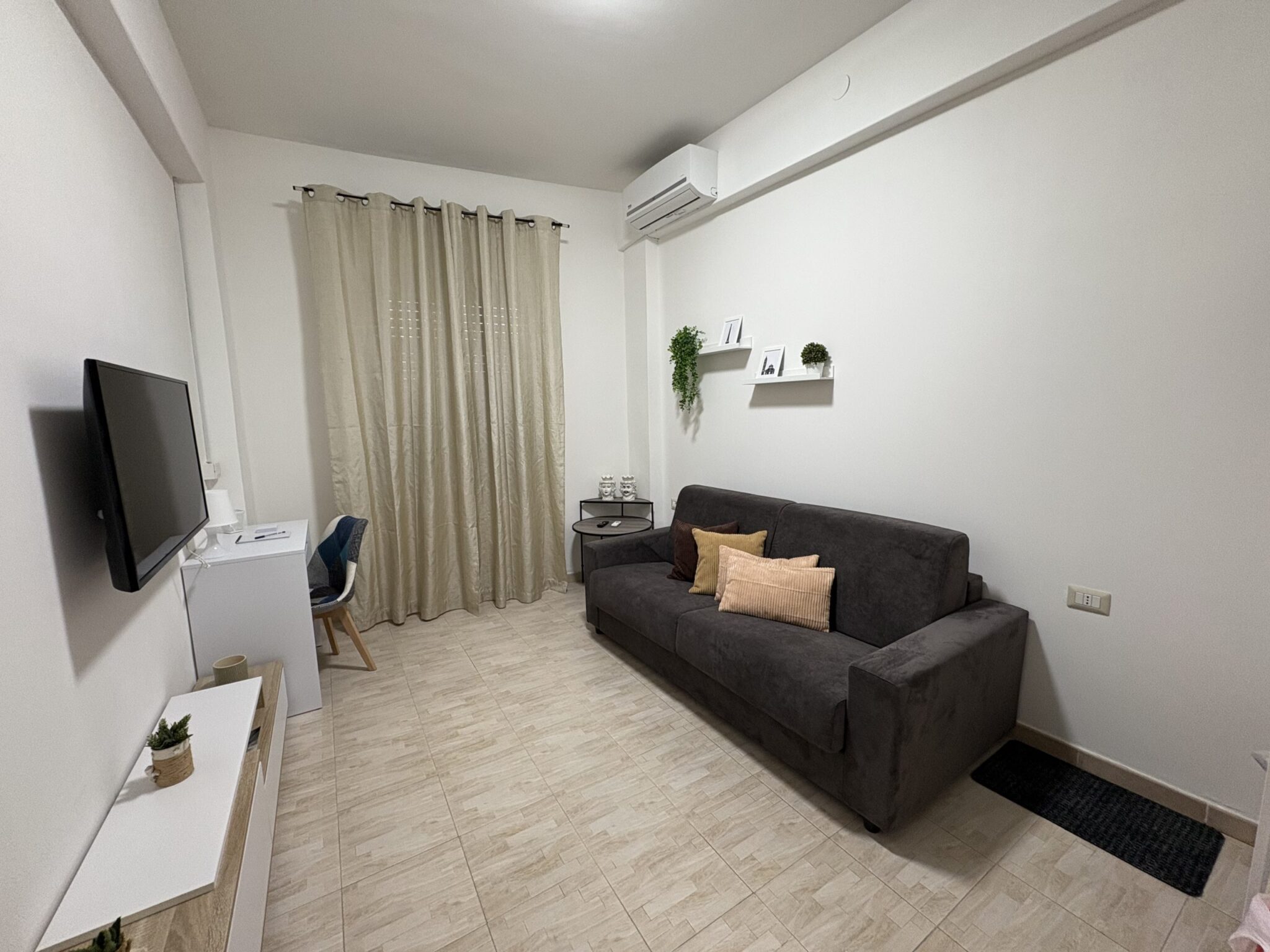 Zona living con divano, televisione e scrivania